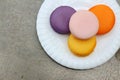 Macaron in white plates on the background of the cement. Royalty Free Stock Photo