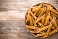 Macaroni on the bowl, wooden background. Royalty Free Stock Photo