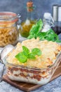 Macaroni casserole with ground beef, cheese and tomato in glass baking dish, vertical