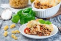Macaroni casserole with ground beef, cheese and tomato on white plate, horizontal