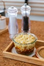 Macaroni Cheese Baked with meat sauce in glass bowl on wooden plate with salt, pepper and cutlery Royalty Free Stock Photo