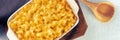 Macaroni and cheese pasta in a casserole panorama, top shot with a wooden spoon Royalty Free Stock Photo