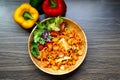 Macaroni pasta with fresh tomato sauce and mixed vegetables in a wooden bowl together with red and yellow bell pepper Royalty Free Stock Photo