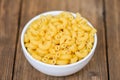 Macaroni top view on bowl and wooden background - close up raw macaroni uncooked delicious pasta or penne noodles Royalty Free Stock Photo