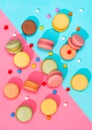 Macaroons candies of different colors placed on a pink and blue pattern Colorful Macaroons