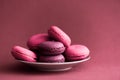 Macarons. Colorful French Macaroons on dark pink background. Dessert or cookies still life