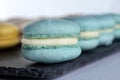 Macarons are laid out on a black slate in beautifully colored rows. Royalty Free Stock Photo