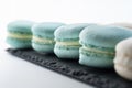 Macarons are laid out on a black slate in beautifully colored rows. White isolate. Royalty Free Stock Photo