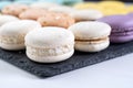 Macarons are laid out on a black slate in beautifully colored rows. Royalty Free Stock Photo