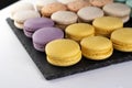 Macarons are laid out on a black slate in beautifully colored rows. Royalty Free Stock Photo