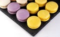 Macarons are laid out on a black slate in beautifully colored rows. Royalty Free Stock Photo