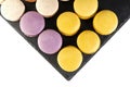 Macarons are laid out on a black slate in beautifully colored rows. Royalty Free Stock Photo