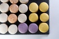 Macarons are laid out on a black slate in beautifully colored rows. Royalty Free Stock Photo