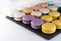 Macarons are laid out on a black slate in beautifully colored rows. Royalty Free Stock Photo