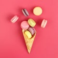 Icecream waffle cone with macarons on pink background