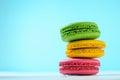 Macaroon cake red and yellow and green on a white table on a light blue background Royalty Free Stock Photo