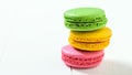 Macaroon cake red and yellow and green on a white wooden table on a white background Royalty Free Stock Photo