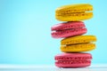 Macaroon cake red and yellow on a white wooden table on a blue Royalty Free Stock Photo