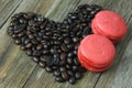 Macaroon dessert and coffee beans arranged in a heart shape on t