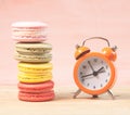 Macaroons and alarm clock on table, vintage stylized photo Royalty Free Stock Photo