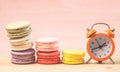 Macaroons and alarm clock on table, vintage stylized photo Royalty Free Stock Photo