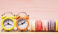 Macaroons and alarm clock on table, vintage stylized photo Royalty Free Stock Photo
