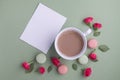 Macaroons, coffee and rose on green background. Top view. Flat lay Royalty Free Stock Photo