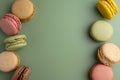 Macaroons colorful cookies. Macarons in bowl, french sweet dessert, top view, green background. Copy space. Royalty Free Stock Photo