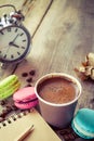 Macaroons, espresso coffee cup, sketch book and alarm clock Royalty Free Stock Photo