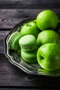 Macaroons and green apples on vintage metal tray.