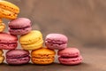 Macaroons. Multicolored Macaroons on a brown background. Pyramid. Pink, yellow and red Macaroons. French cake. Place for Royalty Free Stock Photo