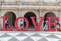 Family in Macau, LOVE letters posing outdoors large lettering red fun and travel