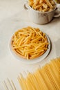 Maccheroni, spiral tortiglioni pasta and raw hard homemade fluted lasagna sheets in flour close-up. real life atmosphere. homemade