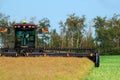 MacDon windrower swather is cutting canola in the field at the wood