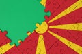 Macedonia flag is depicted on a completed jigsaw puzzle with free green copy space on the left side