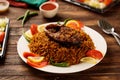 Machboos Hamour or Hamour biryani with tomato sauce and salad served in a dish isolated on wooden table background side view of