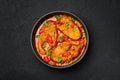 Macher Jhol in black bowl on dark slate table top. Indian cuisine Bengali Fish Curry. Asian food and meal. Top view Royalty Free Stock Photo