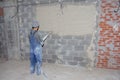 Machine application of plaster to the wall. Plasterer spraying plaster on wall. Professional, painting. Plastering walls in a new Royalty Free Stock Photo