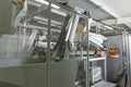 Machine for blowing plastic bottles from PET preforms, industrial conveyor belt in factory interior