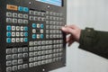Operator use hand turns dial switch control at panel of CNC lathe machine at factory. Close up of control panel.