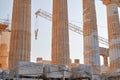 Machine crane between columns of Parthenon temple at the Acropolis, Athens, Greece, at sunset. Restoration process