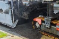 The machine is cutting asphalt, cutting old asphalt with a special machine and loading it into a dumper Royalty Free Stock Photo