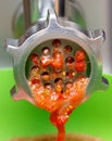 Machine is grinding up tomatoes Royalty Free Stock Photo