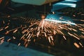 Machine for laser cutting of metal. Laser head cuts the sheet with a beam, sparks scatter in different directions Royalty Free Stock Photo