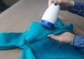 Machine for removing pellets. The girl uses a special device to remove lint from clothes. Restoration of old damaged clothes Royalty Free Stock Photo