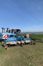 Machinery, equipment for plowing the ground, blue soil stands on green grass against the background of a blue sky. Close-up Royalty Free Stock Photo