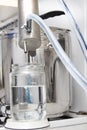 Silver distillation machine is standing on the burner in the kitchen. Royalty Free Stock Photo