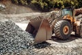 Industrial  - machinery working. Close up of wheel loader loading gravel into dumper trucks Royalty Free Stock Photo