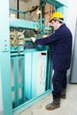 Machinist with spanner adjusting lift mechanism Royalty Free Stock Photo