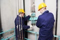 Machinists adjusting lift in elevator hoistway Royalty Free Stock Photo